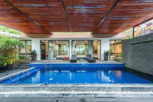 uma piscina numa casa com tecto de madeira em Flamingo Villa Happy BT em Ngọc Quang
