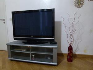 TV a schermo piatto su un supporto TV con vaso di A Casetta a Tivoli