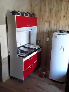 eine kleine Küche mit einem Herd und einem Kühlschrank in der Unterkunft Residencial Maia in Capão da Canoa