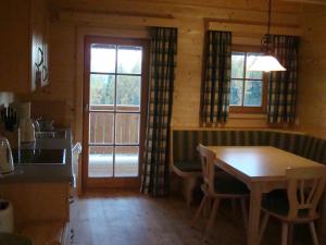 a kitchen with a wooden table and a dining room at Lärchenhütte in Tauplitzalm