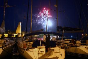 a group of people standing on a boat with fireworks at monolocale "le sciabiche" in Brindisi