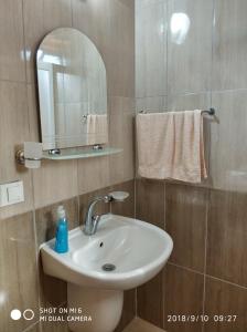 a bathroom with a sink and a mirror and towels at Fire Pansiyon in Cıralı