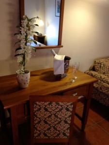 a wooden table with a vase of flowers on top of it at Hotel Xalet Verdú in Arinsal