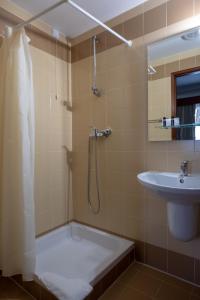 uma casa de banho com um chuveiro e um lavatório. em Hotel Peregrinos de Fatima em Fátima