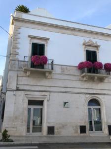 un edificio bianco con due finestre e fioriere di B&B C'era una volta ad Alberobello
