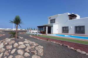 dom z palmą i basenem w obiekcie Hipoclub Villas, Aguamarina 4 w mieście Playa Blanca