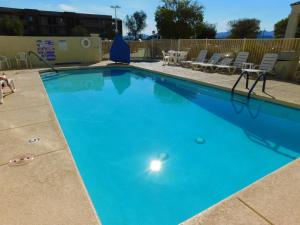 Una gran piscina azul con sillas y una mesa. en Island Suites, en Lake Havasu City