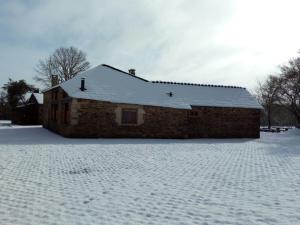una casa de ladrillo con techo cubierto de nieve en Casa Do Grilo en Monfero