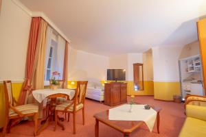 ein Wohnzimmer mit einem Sofa, einem Tisch und Stühlen in der Unterkunft Hotel Residenz Rennhack in Prerow