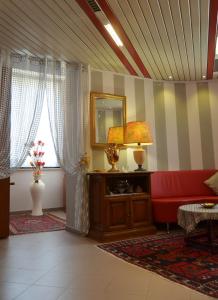 a living room with a red couch and a mirror at Hotel Facioni in Pomezia