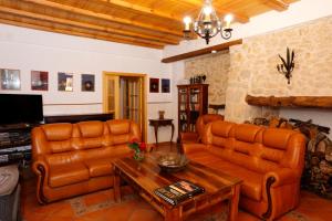 uma sala de estar com sofás de couro e uma mesa em Ca Miquelet - Turistrat em Albocácer
