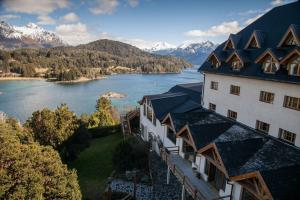 a building with a view of a lake and mountains at Hotel Amancay in San Carlos de Bariloche