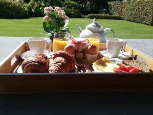 a tray of breakfast food with croissants and orange juice at B&B Bloemenweelde in Kortrijk
