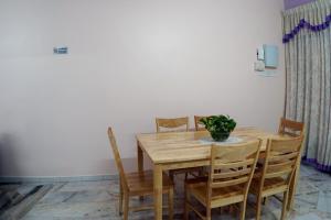 - une table à manger avec des chaises et un vase dans l'établissement Taiping Cozy Homestay, à Taiping