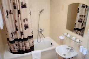 a bathroom with a tub and a sink and a toilet at Hotel Tomas in &Scaron;iauliai