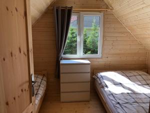 a small room with a bed and a window at Tu Urlop in Mielno