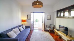 リスボンにあるThe Mouraria Apartmentのリビングルーム(青いソファ、テレビ付)