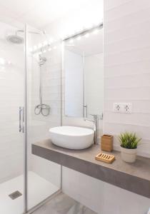 bagno bianco con lavandino e doccia di Archeros Skyview by Valcambre a Siviglia