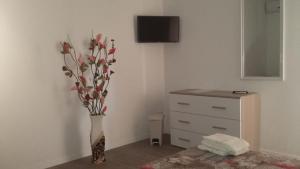 a vase of flowers in a room with a dresser at BeB Oasi in Controguerra