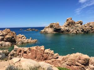 a group of rocks in the water near the ocean at Piccolo paradiso in Costa Paradiso