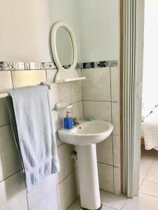 a white bathroom with a sink and a mirror at La Casa de Jessy in Máncora +50 photos