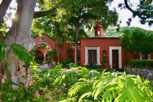 une maison rouge avec une tour d'horloge en haut dans l'établissement Hacienda de los Santos, à Álamos