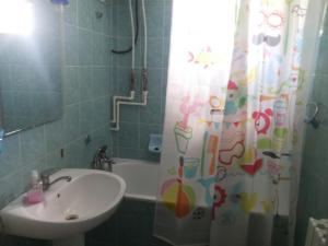 a bathroom with a sink and a shower curtain at Apartament DR in Mangalia +12 photos