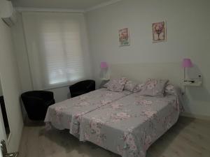 a bedroom with a bed and two chairs and a window at Legazpi apartment in Madrid