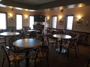 a dining room with tables and chairs and a flat screen tv at Prospector Inn in Creighton
