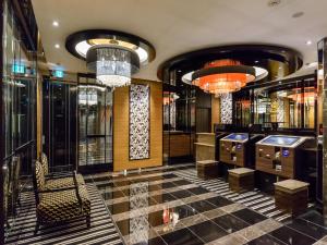 a hotel lobby with chandeliers and a bar at APA Hotel Hatchobori Shintomicho in Tokyo
