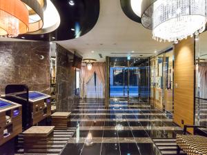 a lobby of a hotel with black tile floors and chandeliers at APA Hotel Hatchobori Shintomicho in Tokyo