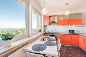 ソポトにあるSea View Apartment Sopotのキッチン(オレンジ色のキャビネット、フルーツ付きのテーブル付)