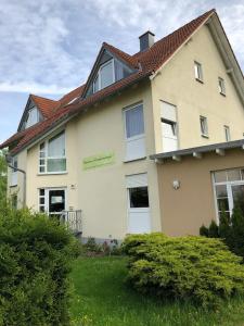 a large white house with a red roof at Pension Preussenstraße Leipzig in Leipzig