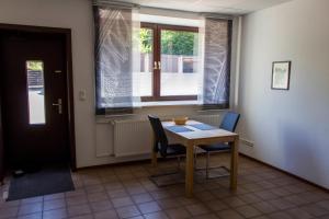 a dining room with a table and chairs and a window at Pension Wesertal in Porta Westfalica