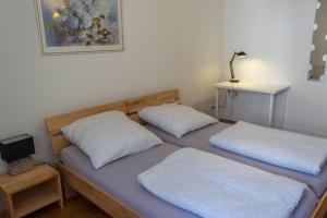 2 Betten mit weißen Kissen in einem Zimmer in der Unterkunft Pension Wesertal in Porta Westfalica