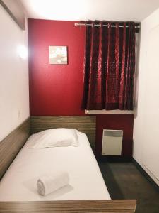 ノイエル・ゴドーにあるFasthotel Lens Noyelles Godaultの赤い壁のドミトリールームのベッド1台分です。