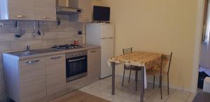 a kitchen with a small table and a white refrigerator at Casa Arancio in Tarquinia