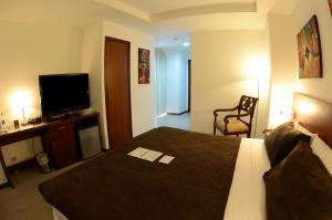 Habitación de hotel con cama y TV de pantalla plana. en HM International Hotel en Guayaquil