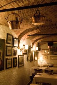 une salle à manger avec deux tables et des photos sur le mur dans l'établissement Locanda la Casetta, à Angera