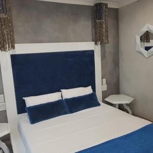 a bedroom with a large bed with blue pillows at Villa Flamenco in Ballito