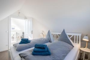ニーンドルフにあるStrandhaus Niendorfのベッドルーム1室(青い枕付きのベッド2台付)