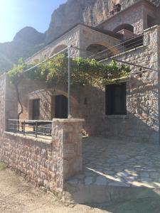 um edifício de tijolos com um alpendre e uma varanda em Leonidio Rock climbing house em Leonidio