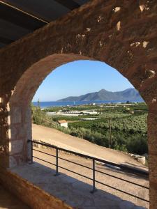 um arco numa parede de pedra com vista para as montanhas em Leonidio Rock climbing house em Leonidio