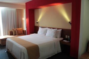 Pokój hotelowy z dużym łóżkiem i krzesłem w obiekcie Holiday Inn Express Guadalajara Expo, an IHG Hotel w mieście Guadalajara