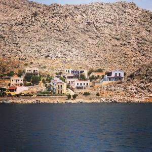 a group of houses on a hill next to the water at Irene Double Apartment Katoi in Symi