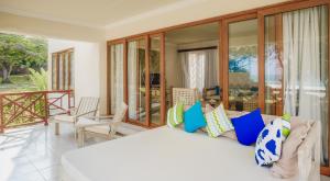 - une chambre avec un grand lit et un balcon dans l'établissement The Zubeida Boutique Resort, à Diani Beach