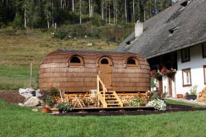 a large wooden house in front of a house at Igluhut Tiny House Winterberghof in Vöhrenbach