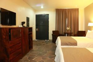 a hotel room with a bed and a flat screen tv at Hotel Villa Tequila in Tequila
