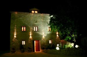 un antiguo edificio de piedra con una puerta roja por la noche en Casa Rural Valle Esgueva, en Burgos