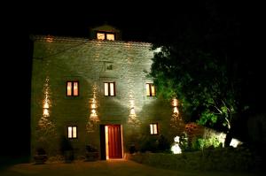 ブルゴスにあるCasa Rural Valle Esguevaの夜間の赤い扉のある古い石造りの建物
